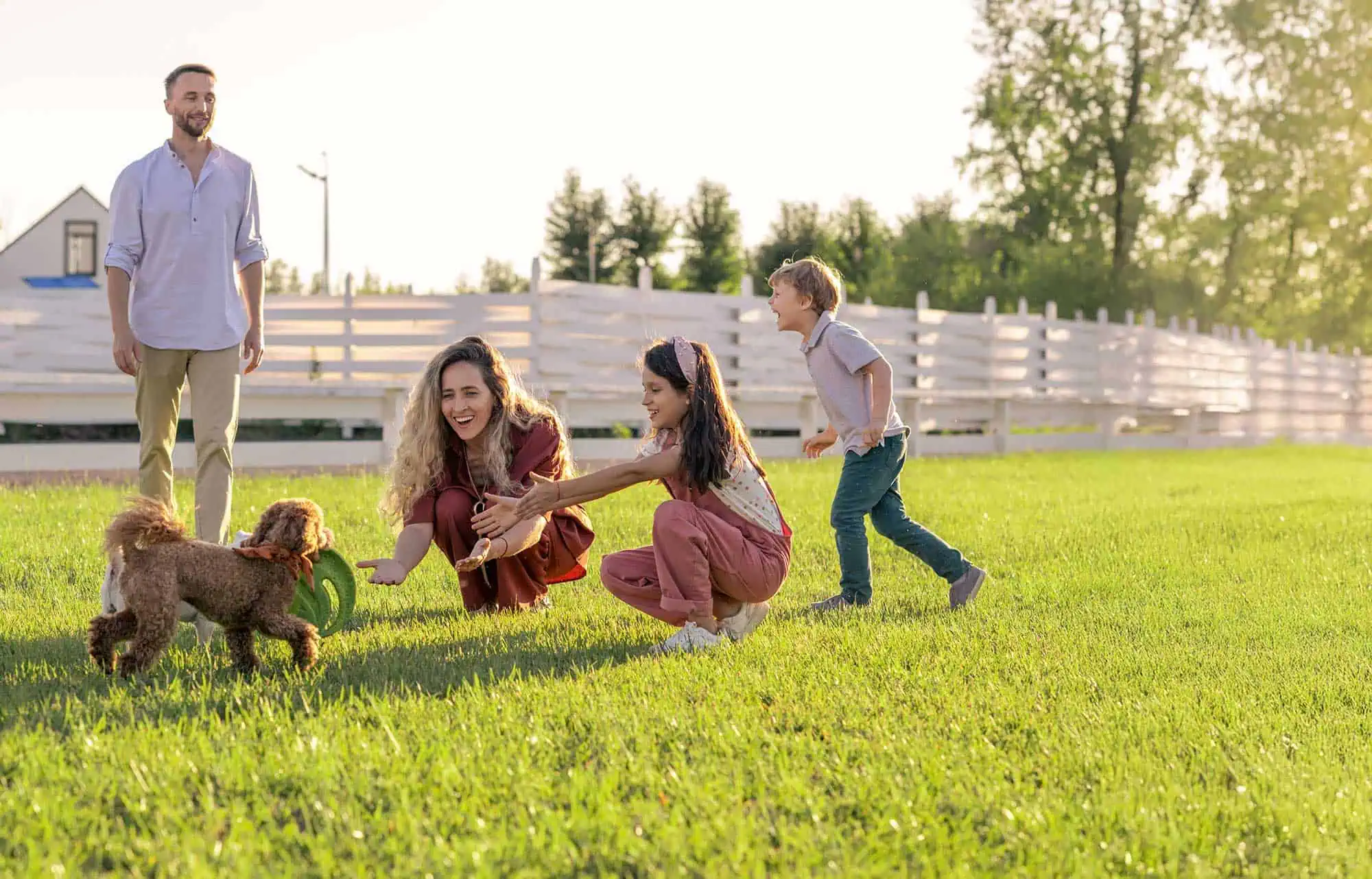 Family playing outdoors with their happy, healthy dog Family playing outdoors with their happy, healthy dog
